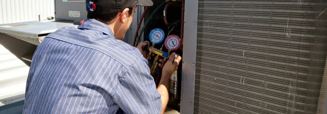 HVAC technician servicing a condenser unit in Vidalia